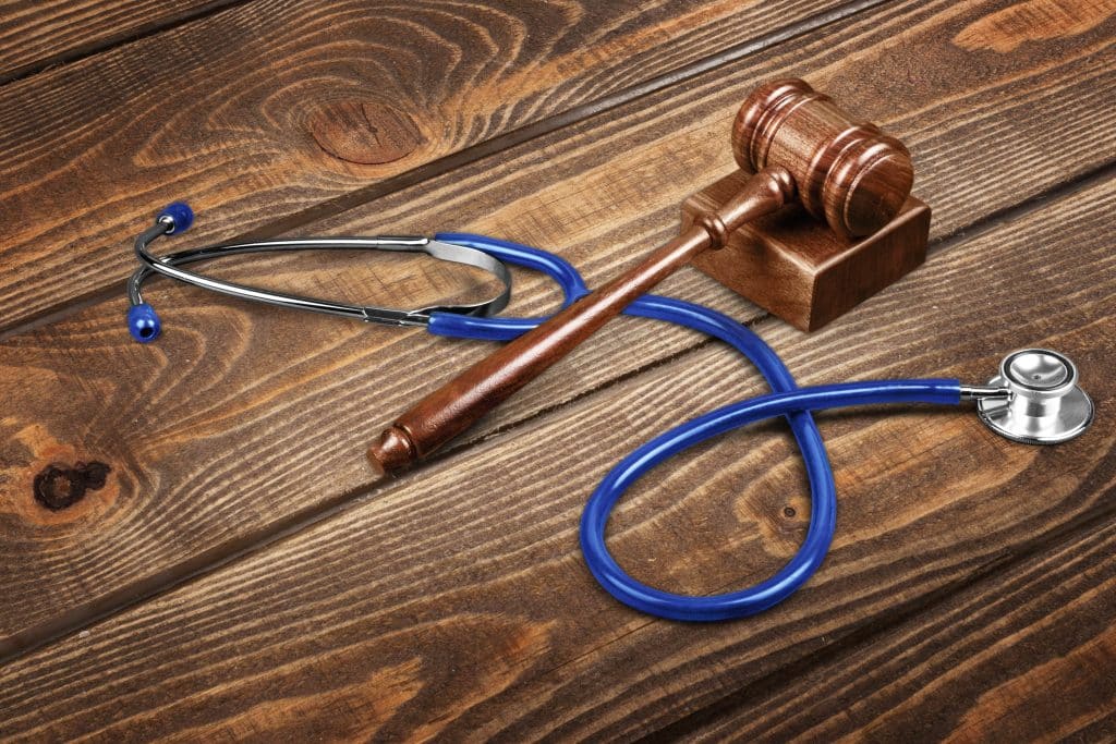 gavel-stethoscope-wooden-background-symbol-photo-bungling-medical-error