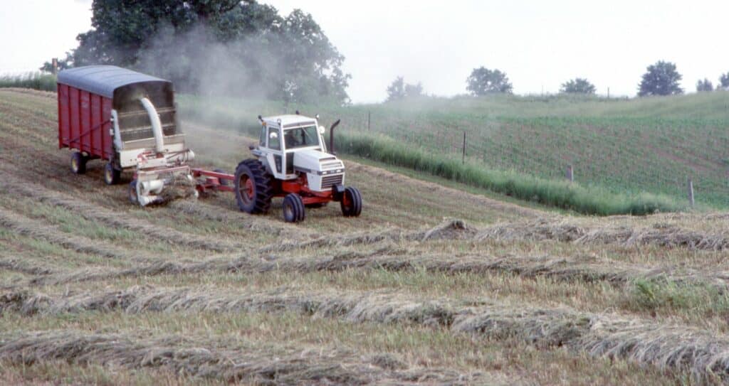 In the late evening a tractor gathers the crops. Canada. 